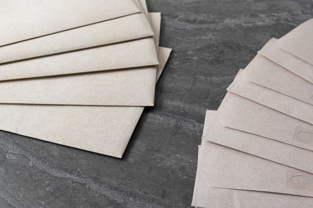 istock Yellow paper envelopes are arranged neatly on a desk 2162327619