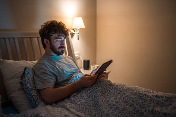 istock Caucasian Male with Insomnia Reading Tablet in Bed at Night 2162330197