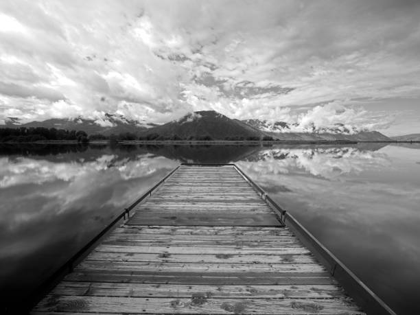 istock Black and white of dock on a lake. 2162336675