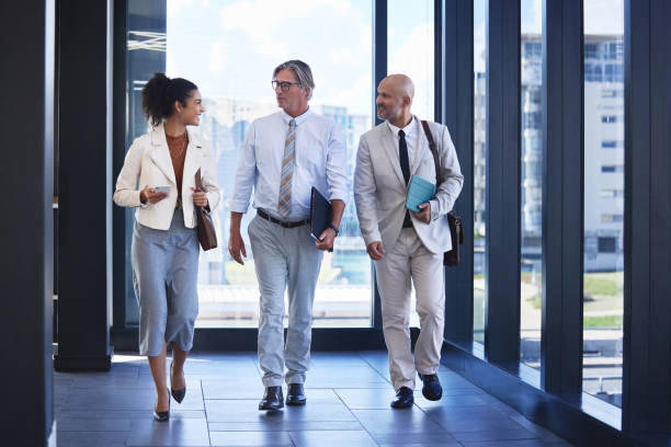istock Business, people and walking or talking in foyer, office and receptionist or escorting work partners. Conversation, employees and speaking for meeting schedule, building and professional in workplace 2162337468