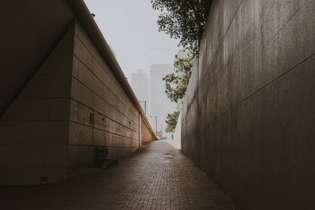 Urban pedestrian walkway under the bridge with skyscrapers on the background