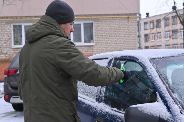 istock a man removes snow from his car 2162346930