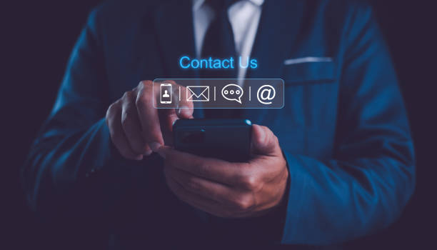 istock Contact us or Customer support hotline people connect. Businessman using a mobile phone with the email, call phone, address, Chat message icons. 2162350129