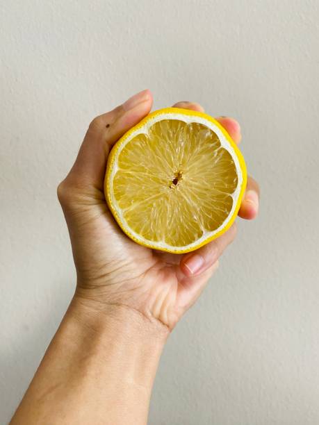 istock A hand holding cutting lemon with with background 2162350964
