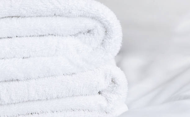 istock White folded terry towels on white bed. 2162351733