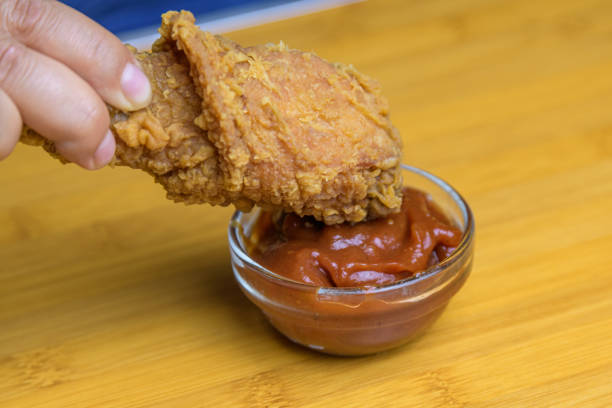 Hand holding crispy fried chicken. Fast food