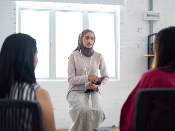 istock A diverse group of people sitting in a circle having a discussion in a modern, bright office space with a green plant in the background 2162353036