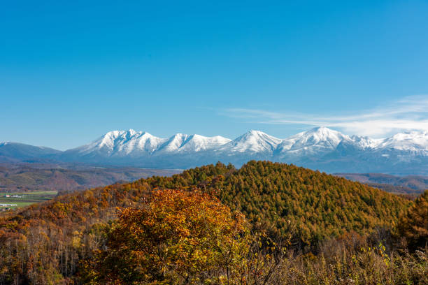 istock Snow-capped mountains beyond the mountains with autumn leaves 2162354117