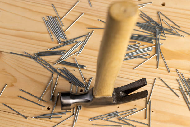 istock nails with small caps and an iron hammer on boards 2162355883