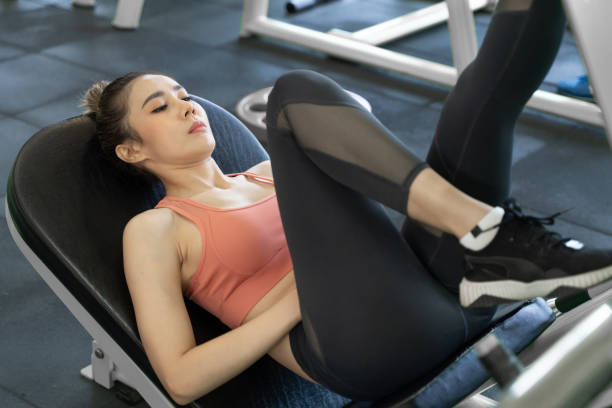 istock Young beautiful woman taking a rest after her leg push up exercise during her morning work out at a gym 2162357439