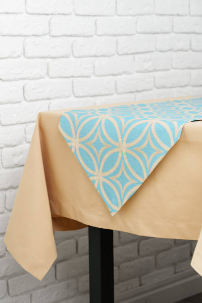 istock Beige Tablecloth on Wooden Table With White Brick Wall Background 2162358689