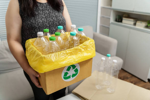 istock Home recycle eco green zero concept Woman throwing empty plastic bottle in recycling bin with yellow garbage bags at home. 2162359561