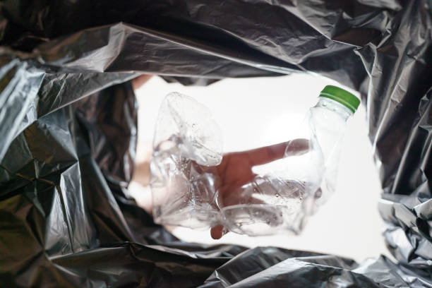 istock Image from inside yellow recycling bag of man throwing empty plastic bottle in recycling bin Home recycle eco green zero concept. 2162359613