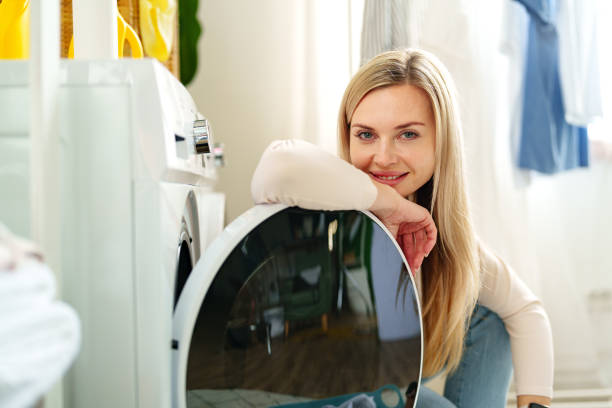 istock Woman Leaning On Washing Machine In Laundry Room 2162360561