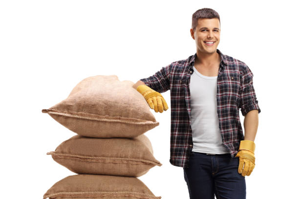 istock Farmer leaning on a pile of burlap sacks 2162366299