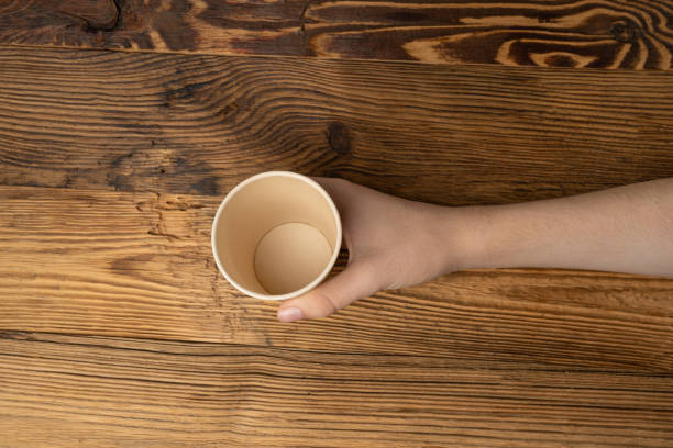 istock Hand Holds Cup, Empty Paper Cup in Hands, Coffee Mug, Teacup, Hot Beverage Mockup, Cup in Arms 2162366534