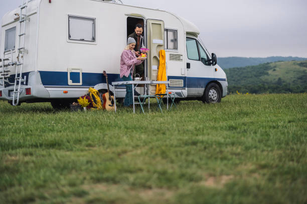 istock Couple Preparing Breakfast Outside RV on a Cloudy Mountain Day 2162376412