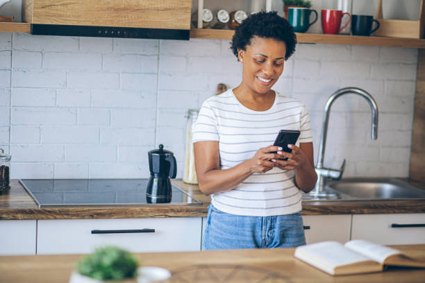 istock Woman uses a mobile phone while waiting for coffee to be made 2162378999