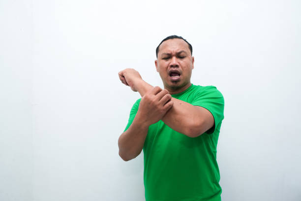 Adult Asian man scratching his hand and showing uncomfortable expression