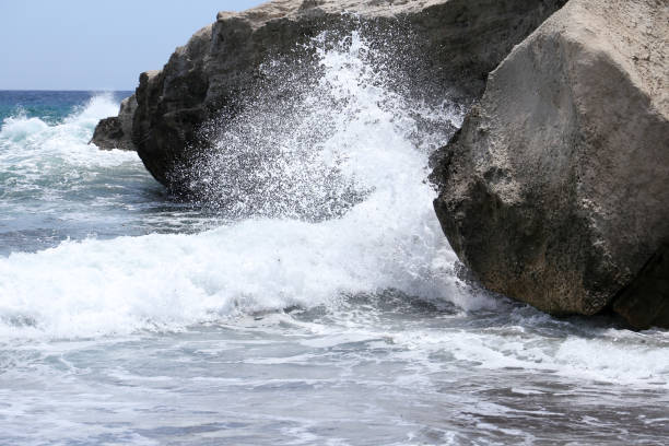 Waves crashing over the rock, background with copy space, full frame horizontal composition