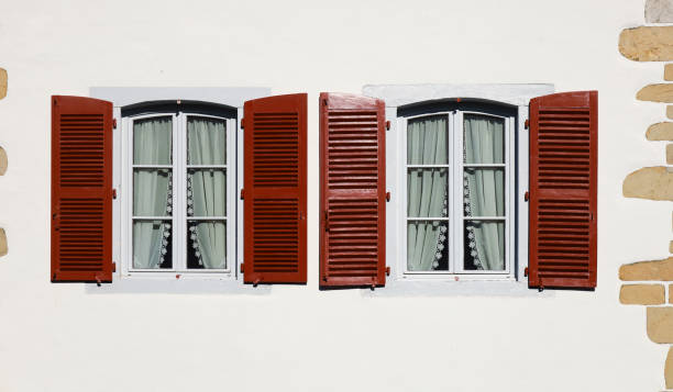 istock White wooden window with curtain on whitewashed facade 2162382979