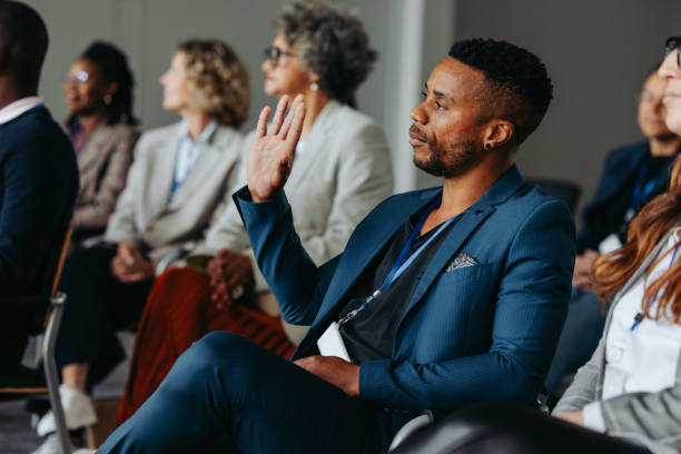 istock Businessman raising hand during conference presentation to ask a question 2162383624