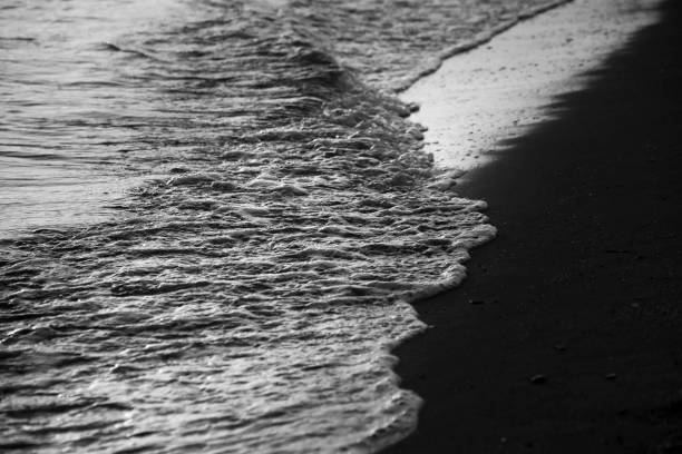 Waves drawing geometric shapes on the shore on the beach at sunset