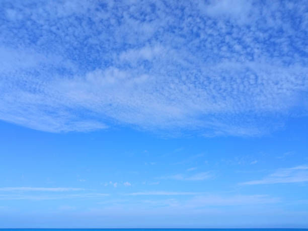 istock Light feather clouds in the blue sky above the sea horizon 2162385822