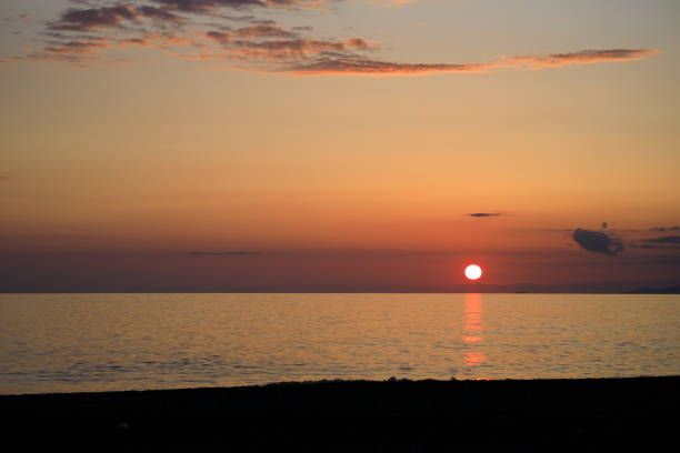 istock The sun is setting over the ocean, casting a warm glow on the water 2162387132