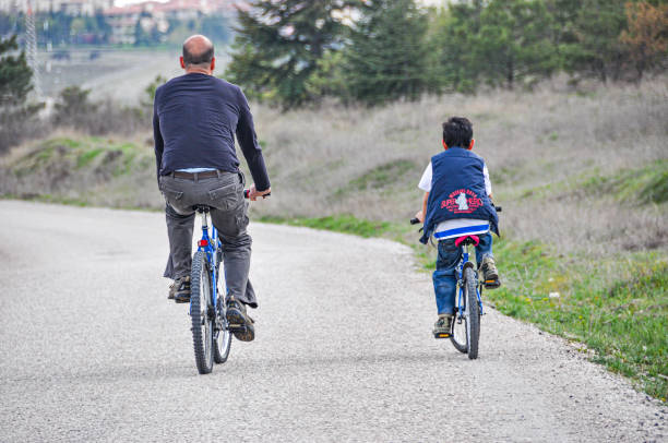 Ankara, Türkiye - April 18, 2010: Father and son riding bicycles on the asphalt