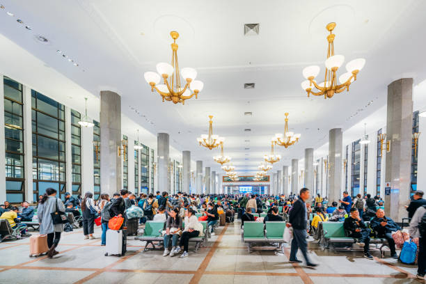 Crowded interior of Beijing Railway Station on October 12, 2023, showcasing people awaiting trains in a bright, spacious waiting area.