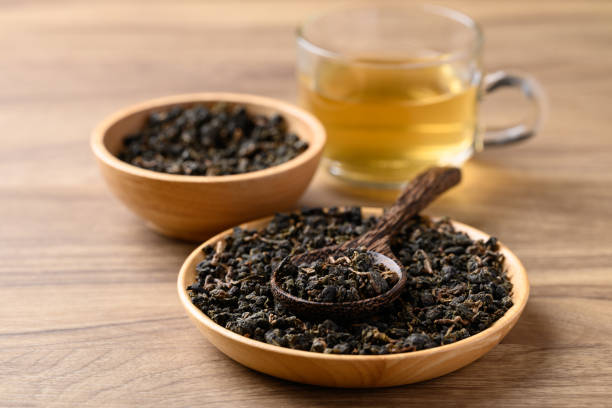 istock Dried Oolong tea leaves with hot tea on wooden background 2162390463