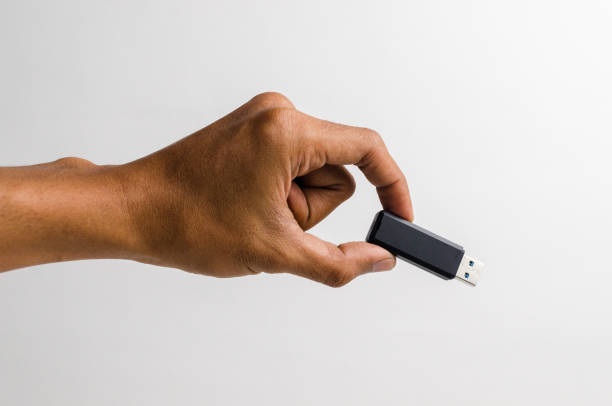 istock Man's hand holding a black USB flash drive 2162391867