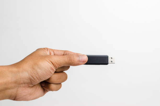 istock Man's hand holding a black USB flash drive 2162391868