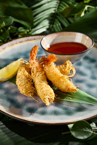 istock Crispy Kataifi Shrimp with Dipping Sauce on Tropical Leaves Background 2162392419