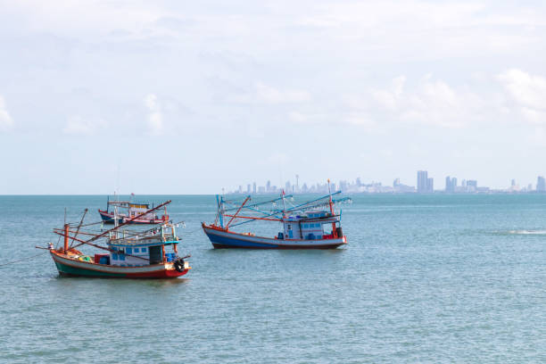 istock Fishing boat floating on the sea with city on background. 2162394708