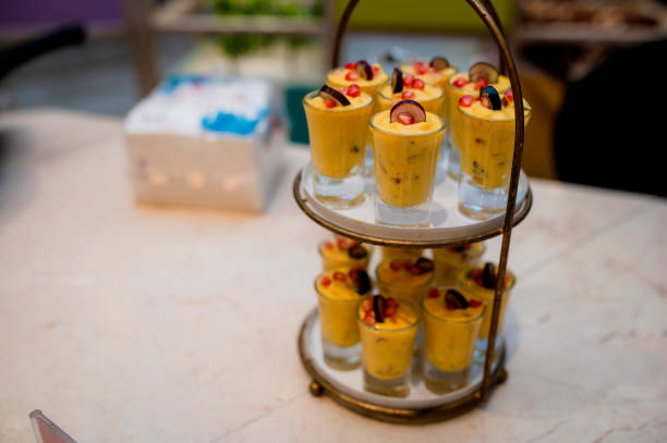 Mousse of mango fruit and pineapple in a glass jar on table