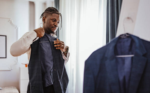 istock Handsome young man dressing for prom night, adjusting suit in mirror reflection 2162399010