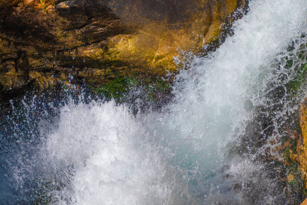 Waterfall, close-up. Splashes of water. A stormy stream of water in a mountain river. Natural background.