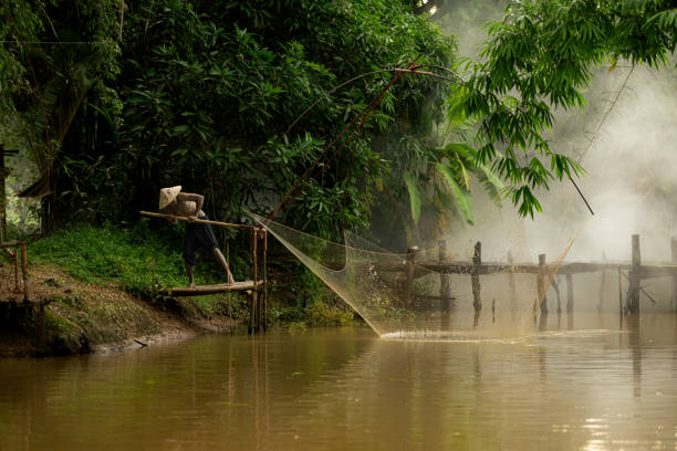 istock A farmer raises a net to capture fish in the river 2162402594