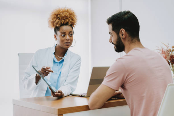 istock Female doctor talking to patient in doctor's office using digital tablet 2162402700