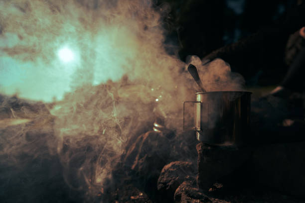 metal mug with morning coffee on campfire