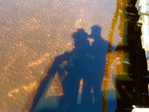 Shadow reflection of a happy couple near the riverside