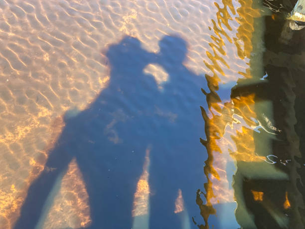 Shadow reflection of a happy couple near the riverside