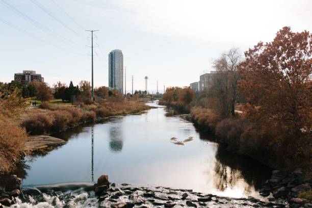 buildings reflected in lake in denver in autumn