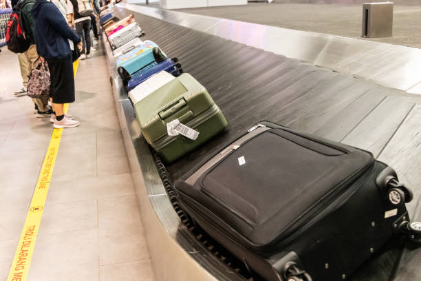 istock Passengers waiting for baggage at airport conveyor belt carousel system 2162407226