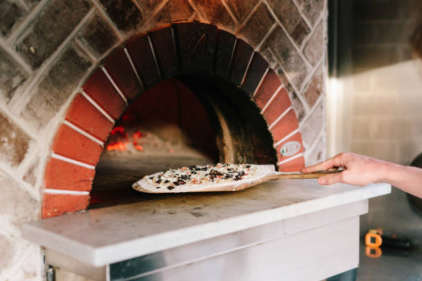 istock Pizza oven with hand putting pizza into oven 2162409026
