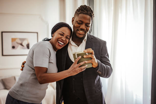 istock Son and mother smiling at gift in bright room 2162410001