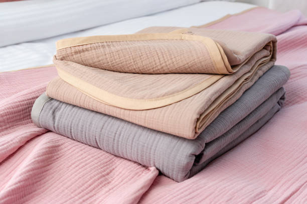 istock Folded Pink and Beige Blankets on a Grey and White Bed With Black Iron Headboard 2162416671