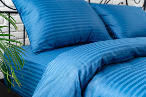 istock Blue Striped Bedding on a Black Metal Bed Frame in a Modern Bedroom 2162416716